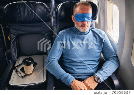 Male passenger dozing off on the plane 70959637