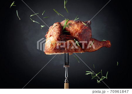Smoked chicken on a fork sprinkled with rosemary. 70961847