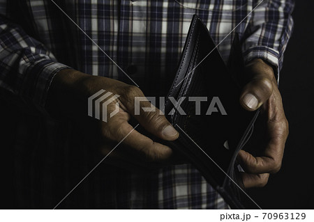 Close-up for a man standing and holding empty wallet. Wallet out of money. 70963129