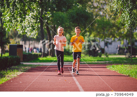 Kids run. Healthy sport. Child sport, heterosexual twins running on track, fitness. Joint training. Running training outdoor brother and sister pre-teen. Jogging with friend. Children athletes 70964049