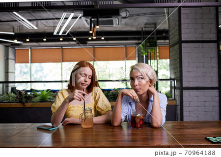 two caucasian ladies are bored of spending time at the bar 70964188