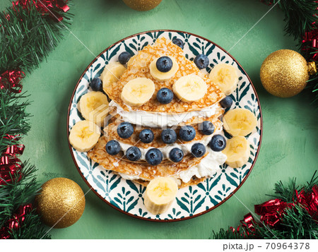 Christmas tree shaped crepes with blueberry, quark Christmas tree shaped crepes with blueberry, quark 70964378