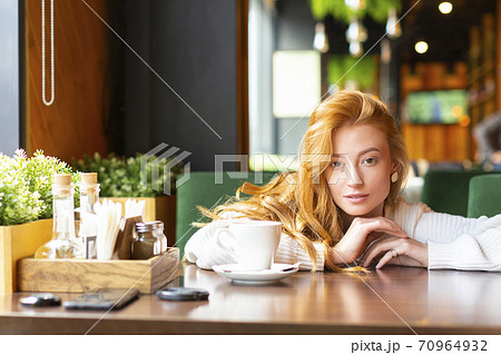 Woman at a cafe drinks tea or coffee. Woman at a cafe drinks tea or coffee. 70964932