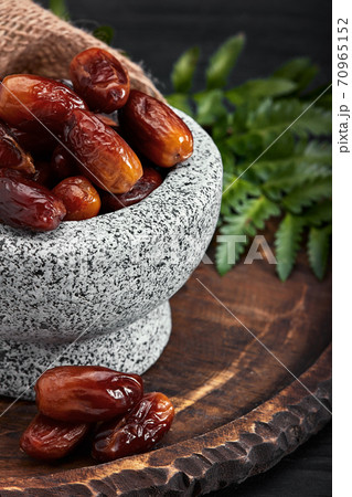 Bowl of dried dates on dark wooden background Bowl of dried dates on dark wooden background 70965152