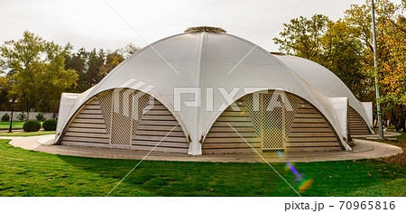 Summer-type cafe with cloth tent on the roof in the form of a dome with wooden entrance doors 70965816