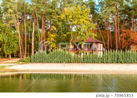 A small complex hotel in the forest consisting of several houses in pines on the banks of the river. A small complex hotel in the forest consisting of several houses in pines on the banks of the river. 70965855