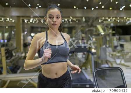 Woman Running on Treadmill 70966435