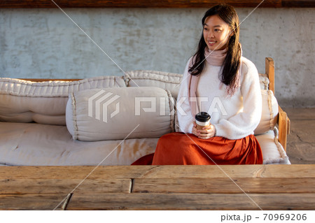 冬のカフフェのソファでコーヒーを飲む長い髪の女性 冬のカフフェのソファでコーヒーを飲む長い髪の女性 70969206