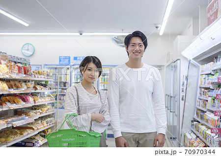 コンビニで買い物をする男女 コンビニで買い物をする男女 70970344