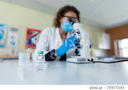 Vial bottle with Covid-19 text on table in laboratory Vial bottle with Covid-19 text on table in laboratory 70975565
