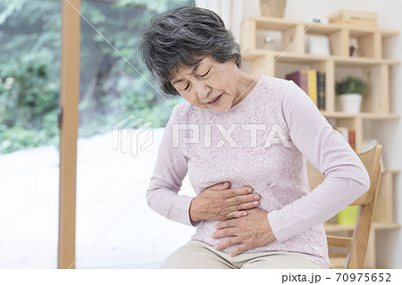 腹痛が辛いシニア女性 70975652