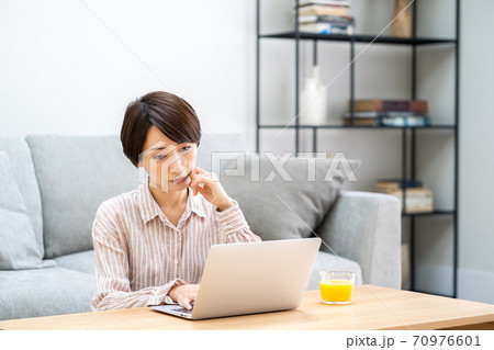 リビングでテレワーク中のミドル女性。 70976601