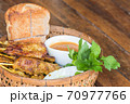 Pork satay with peanut sauce in basket. 70977766