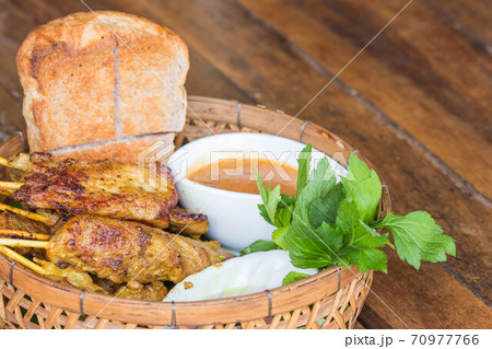 Pork satay with peanut sauce in basket. Pork satay with peanut sauce in basket. 70977766