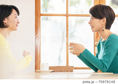 カフェで友達とお喋りする女性 70978148