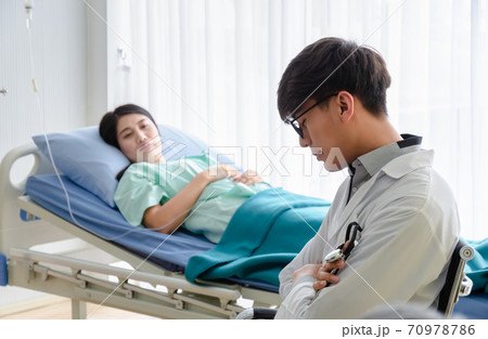 Tired Doctor in white uniform napping at hospital ward for caring patient. 70978786