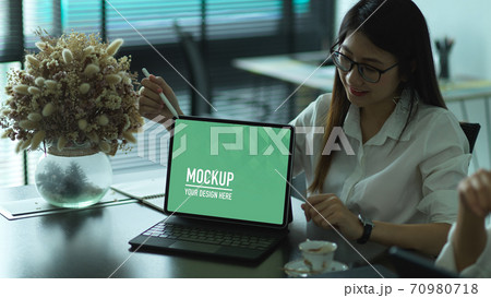 Businesswoman explaining her idea and showing mock up laptop computer 70980718