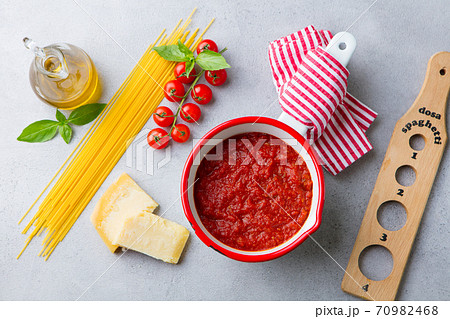 Pasta cooking ingredients, spaghetti, tomato sauce, parmesan cheese. Grey background. Top view. 70982468