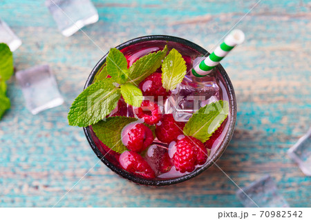 Raspberry cocktail, fizz, lemonade, ice tea with fresh mint on blue wooden background. Close up. Top view. 70982542