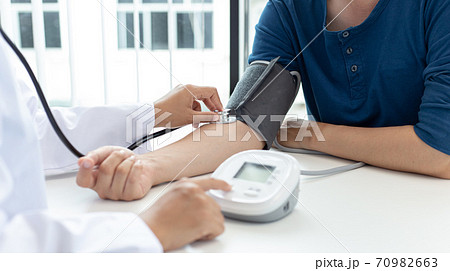 Female doctors use blood pressure monitors and stethoscope to measure pulse Diagnose the patient's disease in a modern hospital medical laboratory, Medical treatment and health care concept. Female doctors use blood pressure monitors and stethoscope to measure pulse Diagnose the patient's disease in a modern hospital medical laboratory, Medical treatment and health care concept. 70982663