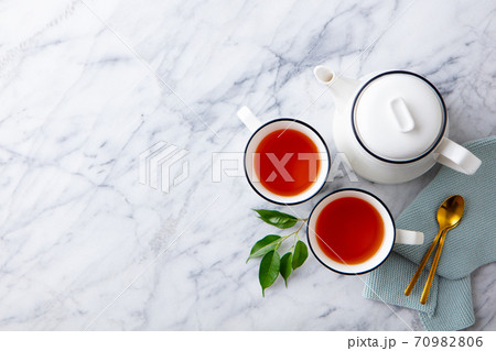 Tea in mugs with teapot on marble background. Copy space. Top view. 70982806
