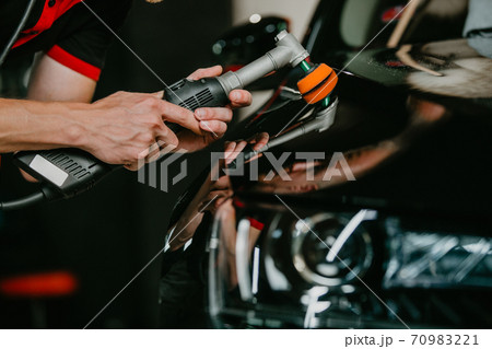 Close up of car detailist hands, cleaning or pilishing the car by poliermaschine, car detailing concept 70983221
