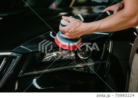 Close up of car detailist hands, cleaning or pilishing the car by poliermaschine, car detailing concept Close up of car detailist hands, cleaning or pilishing the car by poliermaschine, car detailing concept 70983224