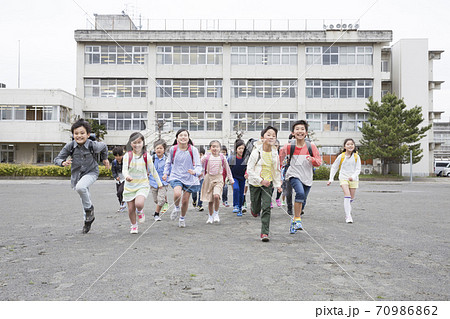 校庭を走る小学生 70986862