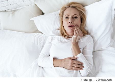 Top view of a woman who holds a bad tooth. 70988286