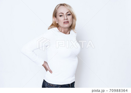 Woman on a white background suffers from back pain Woman on a white background suffers from back pain 70988364