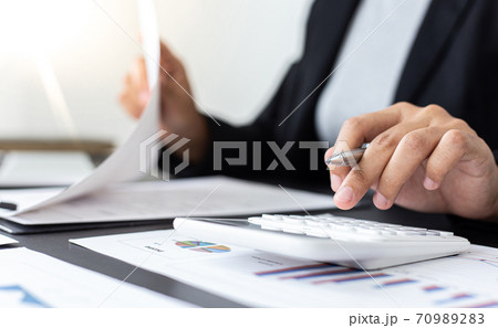 Accounting businessmen are calculating income-expenditure and analyzing real estate investment data, Financial and tax systems concept. Accounting businessmen are calculating income-expenditure and analyzing real estate investment data, Financial and tax systems concept. 70989283