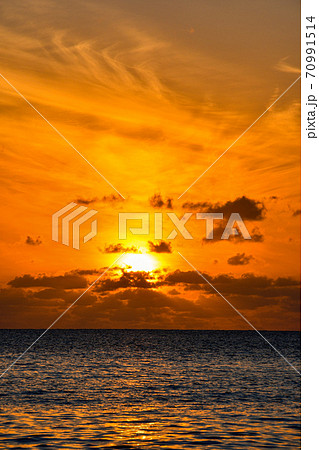 小笠原の父島の夕焼けと雲と海の綺麗な波模様の写真素材