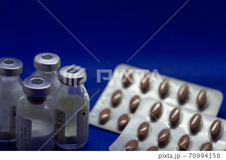 Vaccine bottles with many pills 70994158