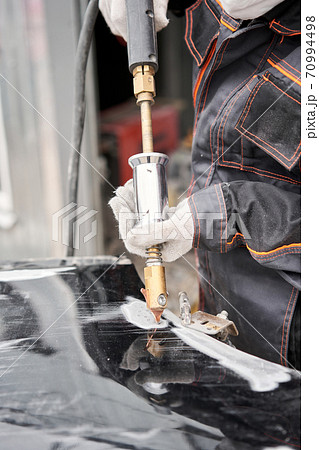 Spotter, a Welding machine for straightening dents on the car body. spot welding of metal. Repair service worker fix damaged car. 70994498