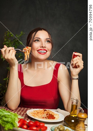Nice woman eating pasta spaghetti and chatting in italian restaurant 70994796