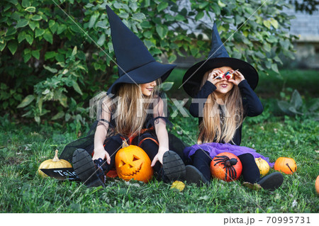 Happy Halloween. Children in suits and with pumpkins having fun outdoor 70995731