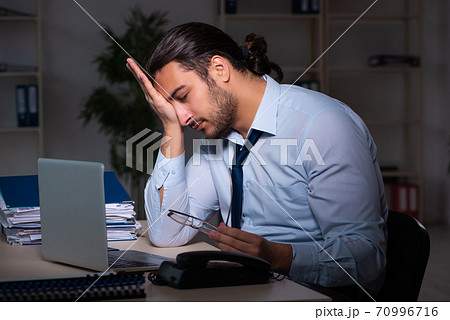 Young businessman working late in the office 70996716