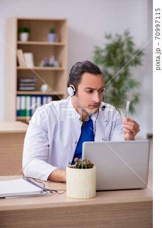Young male doctor in telemedicine concept Young male doctor in telemedicine concept 70997115