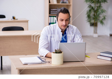 Young male doctor in telemedicine concept Young male doctor in telemedicine concept 70997128