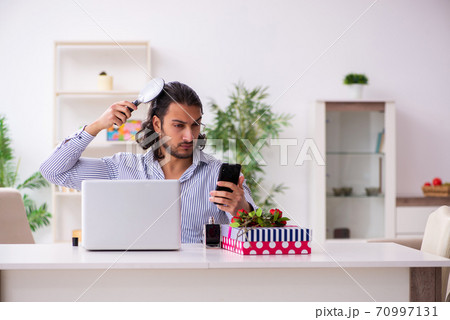 Young man in christmas concept at home Young man in christmas concept at home 70997131