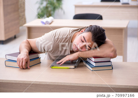 Young male student preparing for exams at library 70997166