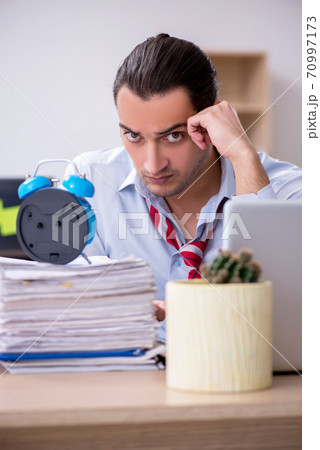 Young male employee in time management concept Young male employee in time management concept 70997173