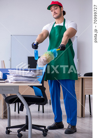 Young male contractor cleaning the office 70999727