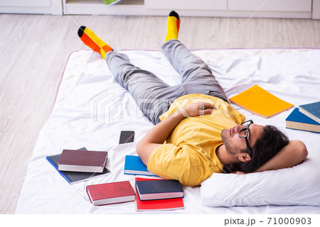 Young male student preparing for exams at home 71000903