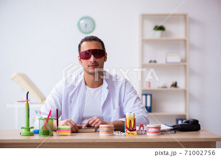 Young male dentist working in the clinic Young male dentist working in the clinic 71002756