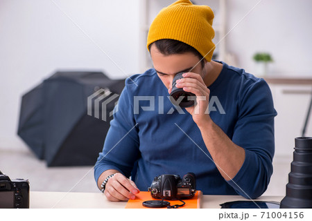 Young male photographer working in the studio 71004156