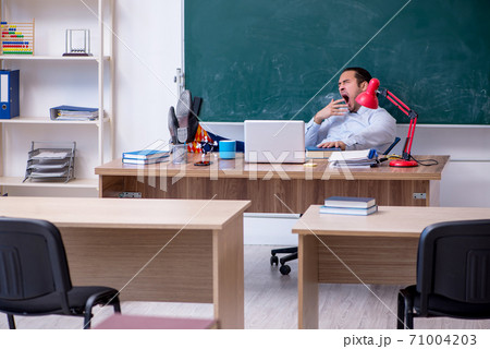 Young male teacher in front of green board Young male teacher in front of green board 71004203