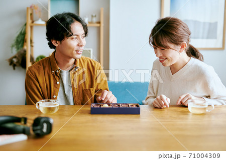 チョコレートを眺める女性と男性 チョコレートを眺める女性と男性 71004309