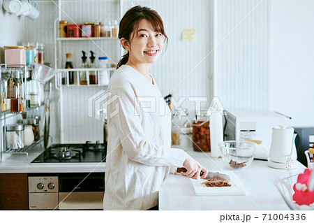 キッチンでチョコレートをカットする女性 キッチンでチョコレートをカットする女性 71004336