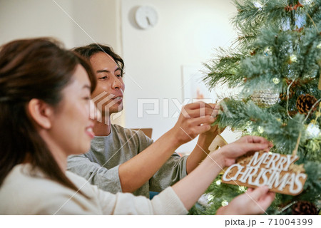 クリスマスツリーに飾り付けをする女性と男性 71004399